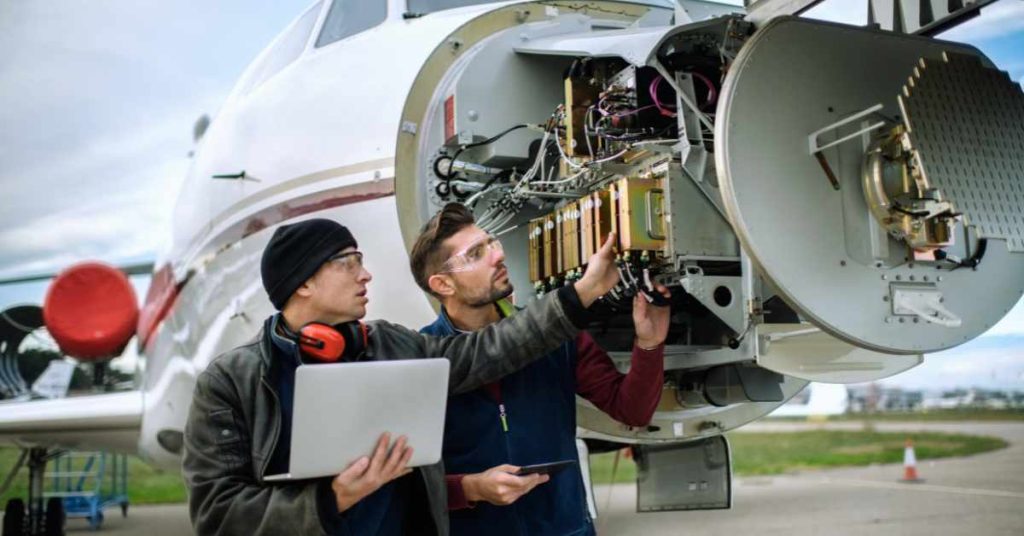 2  person checking aircraft for issues.